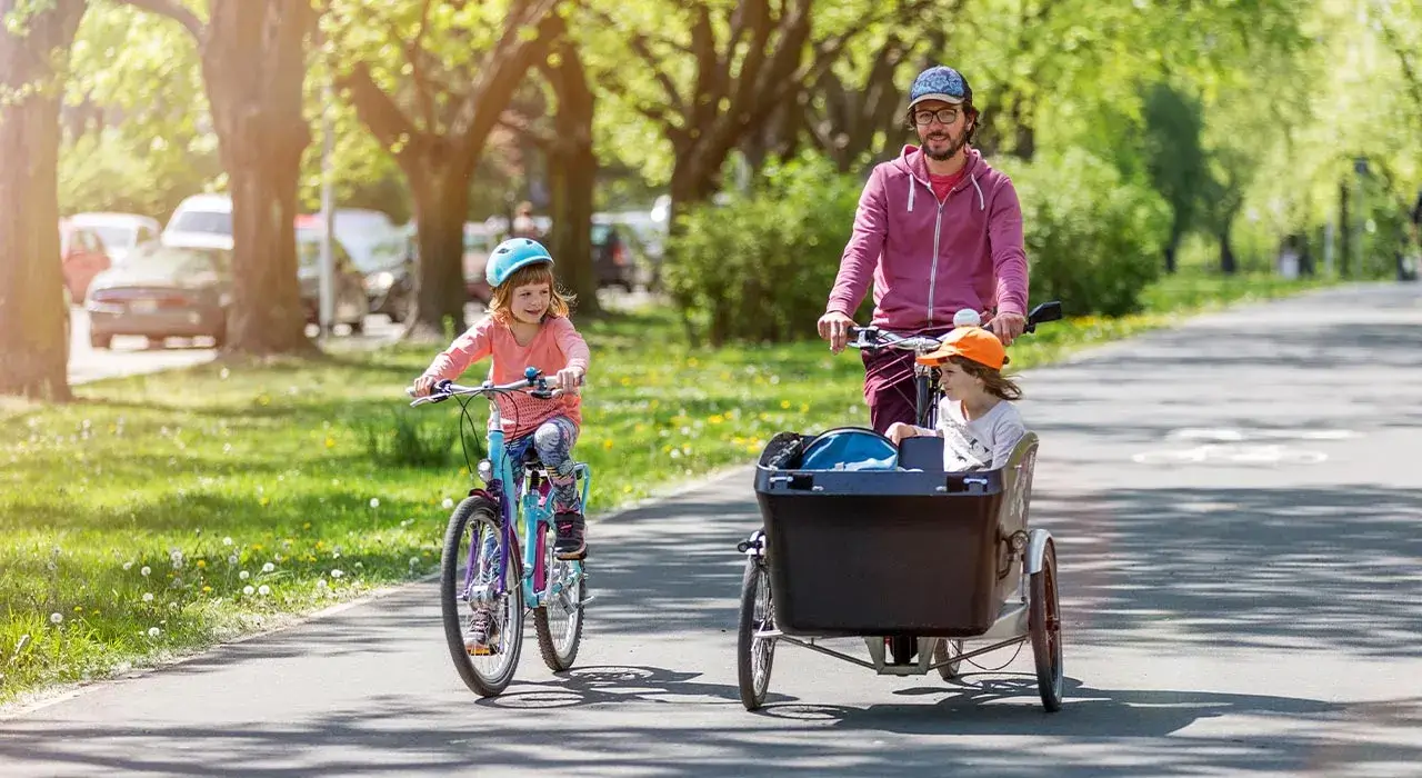 Genitore che porta in bici dei bambini