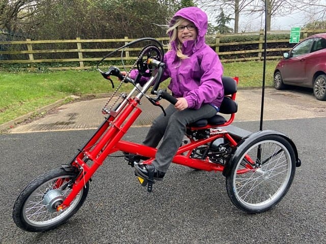 donna sorridente su triciclo handbike